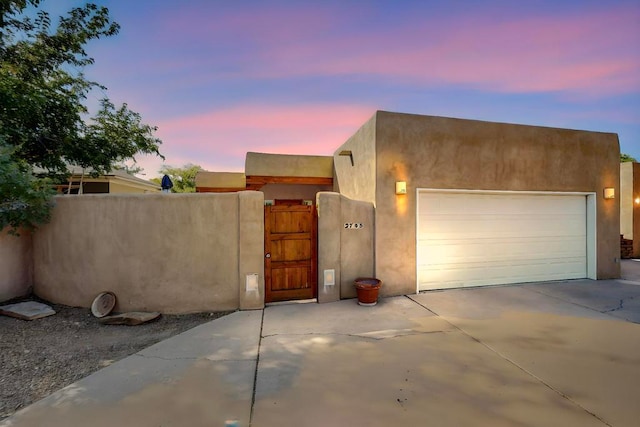 pueblo revival-style home with a garage