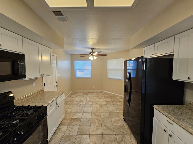 kitchen with light stone countertops, black appliances, and white cabinets