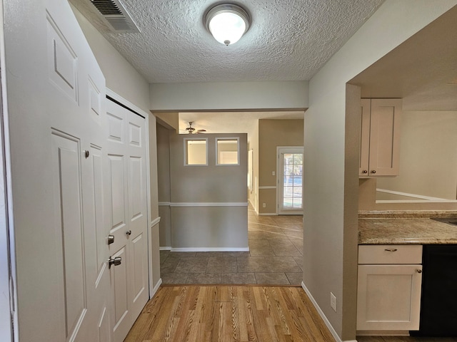 hallway featuring a textured ceiling and light wood-type flooring