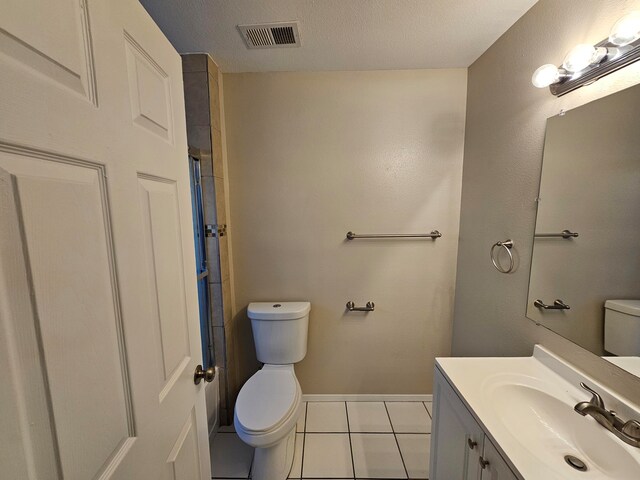 bathroom with vanity, toilet, a textured ceiling, and tile patterned flooring