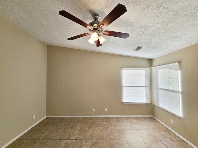 tiled empty room with ceiling fan, a textured ceiling, and vaulted ceiling