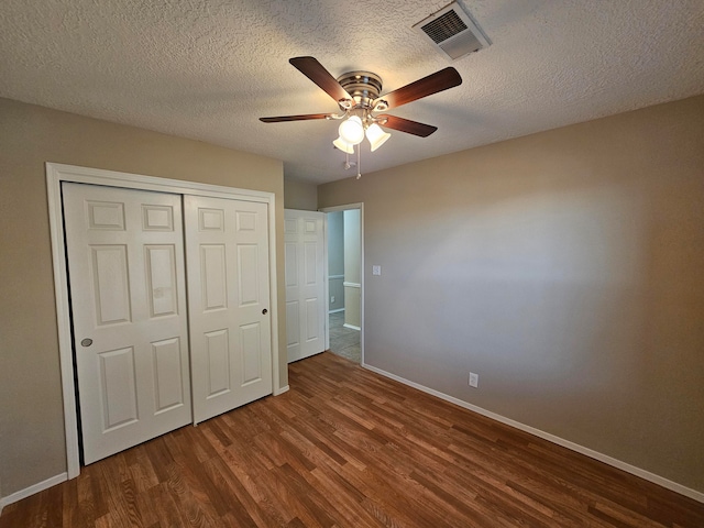 unfurnished bedroom with a closet, a textured ceiling, wood-type flooring, and ceiling fan