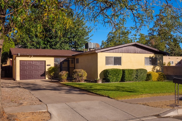 ranch-style house with a front yard, a garage, and central air condition unit