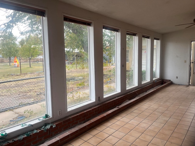 unfurnished sunroom featuring ceiling fan