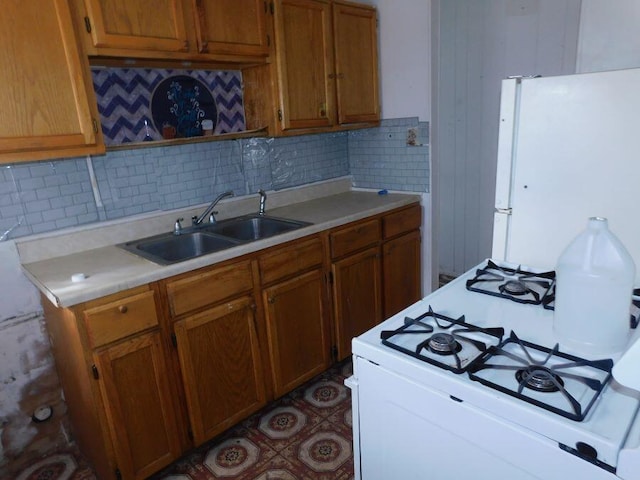 kitchen with sink, decorative backsplash, and white appliances