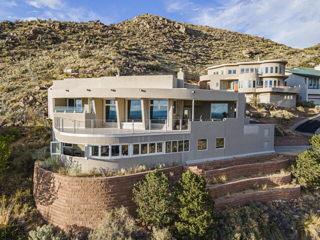 back of house featuring a mountain view and a balcony