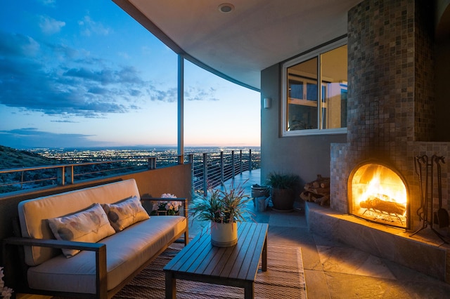 balcony at dusk with an outdoor living space with a fireplace