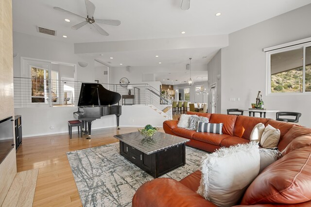 living room with ceiling fan and light wood-type flooring