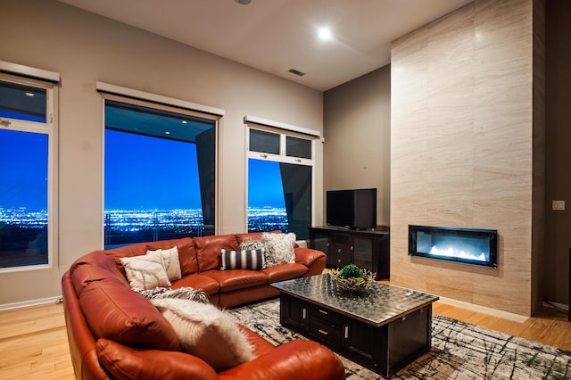 living room featuring light hardwood / wood-style floors and a tile fireplace