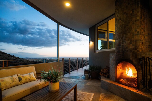 balcony at dusk featuring an outdoor living space with a fireplace