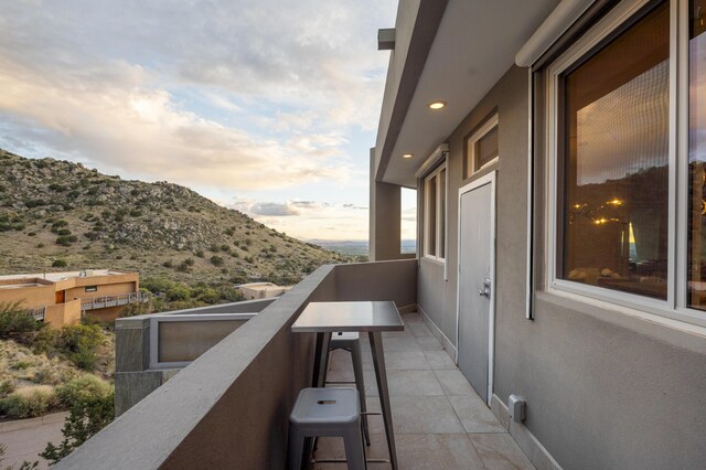 balcony at dusk featuring a mountain view