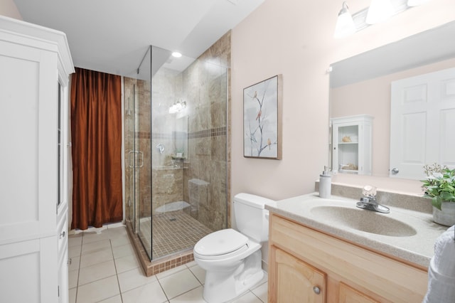 bathroom with tile patterned floors, a shower with door, vanity, and toilet