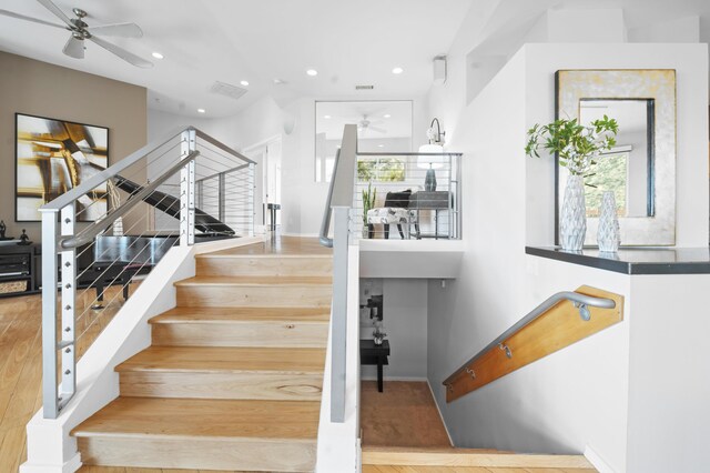 stairway featuring hardwood / wood-style floors and ceiling fan