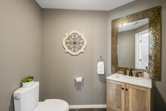 bathroom featuring tile patterned floors, vanity, and toilet