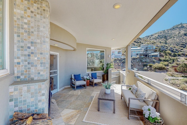 balcony with an outdoor living space and a mountain view