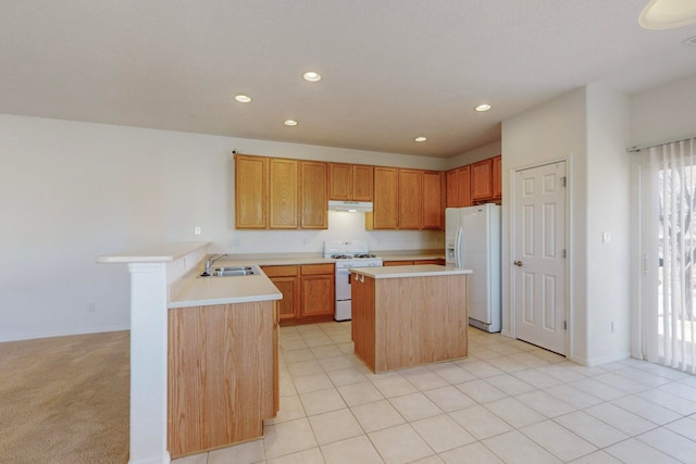 kitchen featuring kitchen peninsula, a kitchen island, sink, light colored carpet, and white appliances