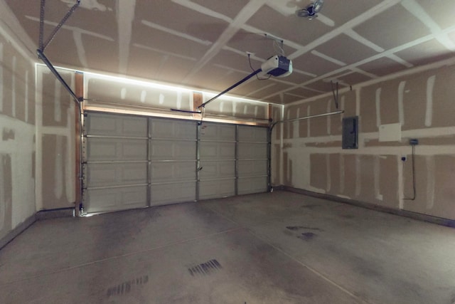 garage with a garage door opener and electric panel