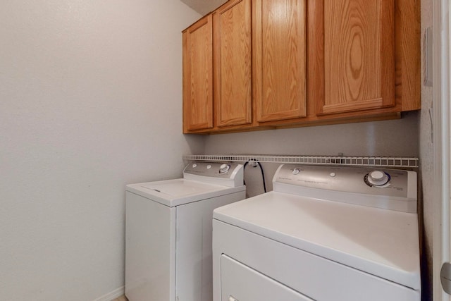 washroom with washer and clothes dryer and cabinets