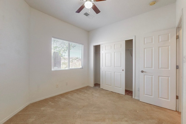 unfurnished bedroom with light carpet, a closet, and ceiling fan