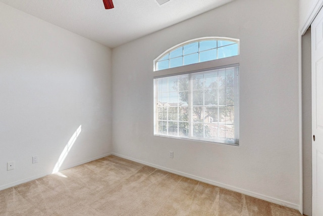 carpeted spare room featuring ceiling fan