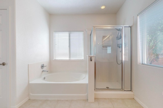 bathroom with independent shower and bath, a healthy amount of sunlight, and tile patterned flooring