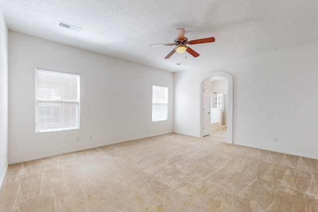 carpeted spare room with a textured ceiling and ceiling fan