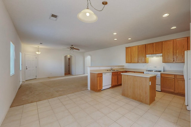 kitchen featuring sink, a kitchen island, pendant lighting, and white appliances