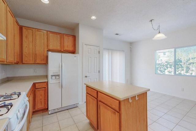 kitchen featuring hanging light fixtures, a center island, light tile patterned flooring, a textured ceiling, and white appliances