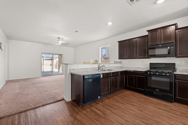 kitchen featuring dark brown cabinetry, black appliances, dark wood-type flooring, and sink