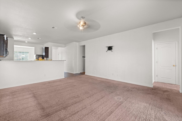 unfurnished living room with dark carpet and ceiling fan