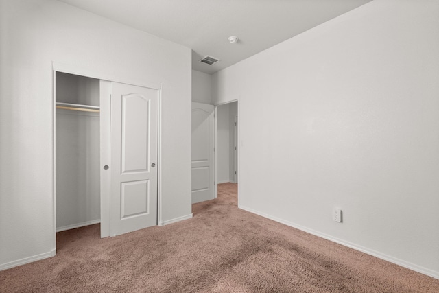 unfurnished bedroom featuring a closet and light carpet