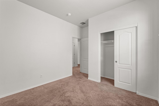 unfurnished bedroom with a closet and light carpet