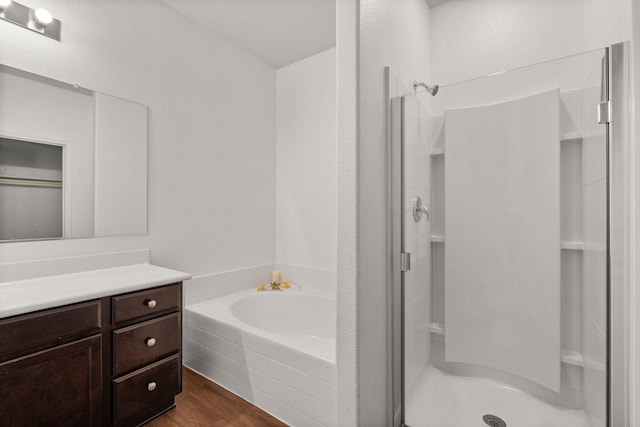 bathroom with vanity, hardwood / wood-style floors, and plus walk in shower