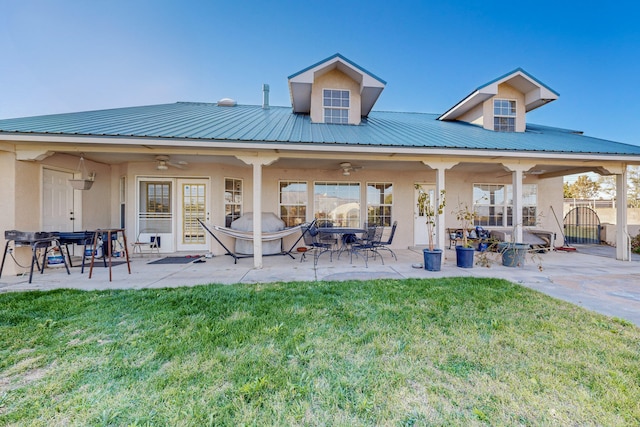 rear view of property with a patio, a lawn, and ceiling fan