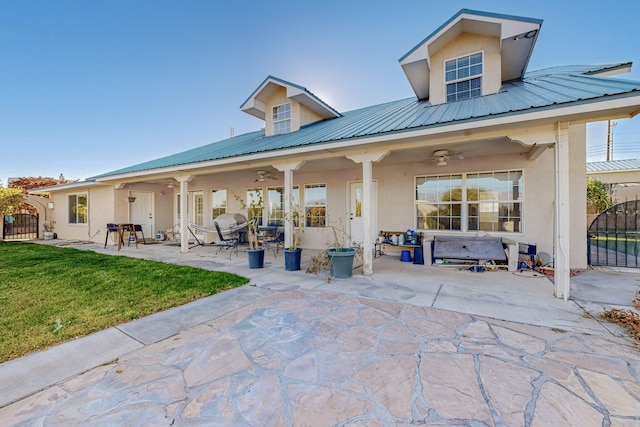 back of house featuring ceiling fan, a patio, and a lawn