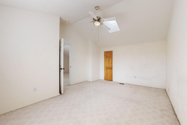 spare room with carpet, high vaulted ceiling, ceiling fan, and a skylight