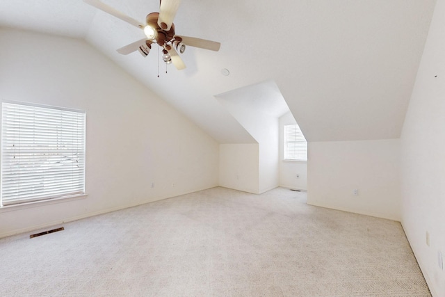 bonus room with light carpet, lofted ceiling, and ceiling fan