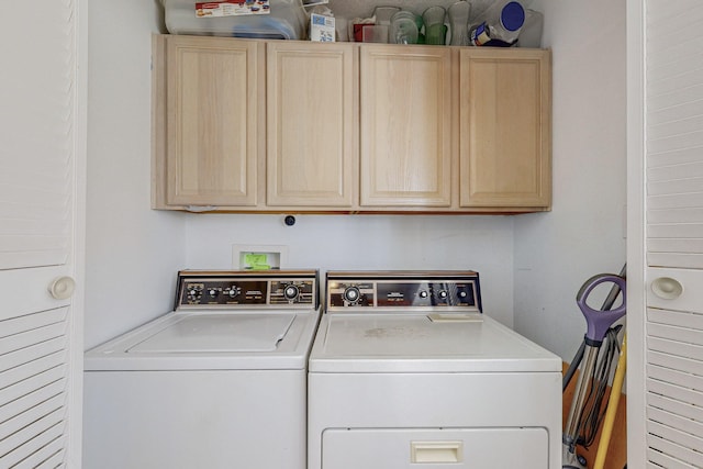 washroom featuring separate washer and dryer and cabinets