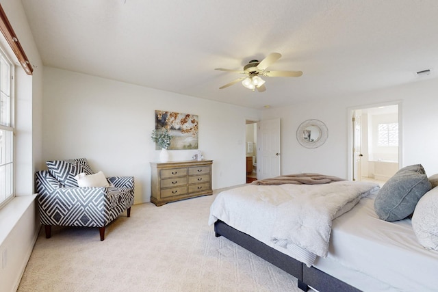 carpeted bedroom featuring ceiling fan and ensuite bath