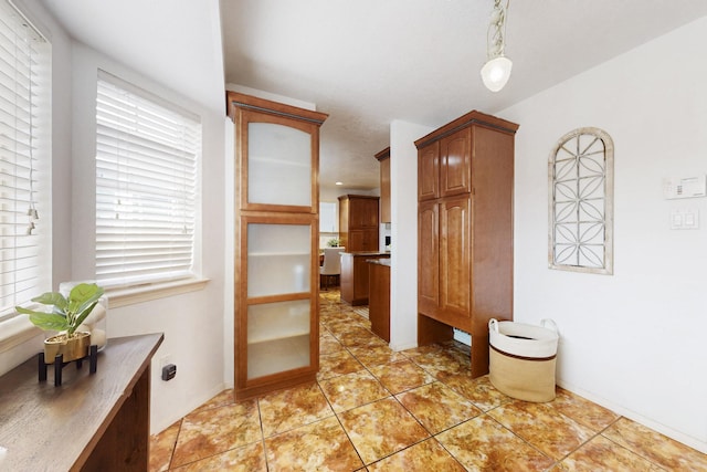 hall featuring a wealth of natural light and light tile patterned floors