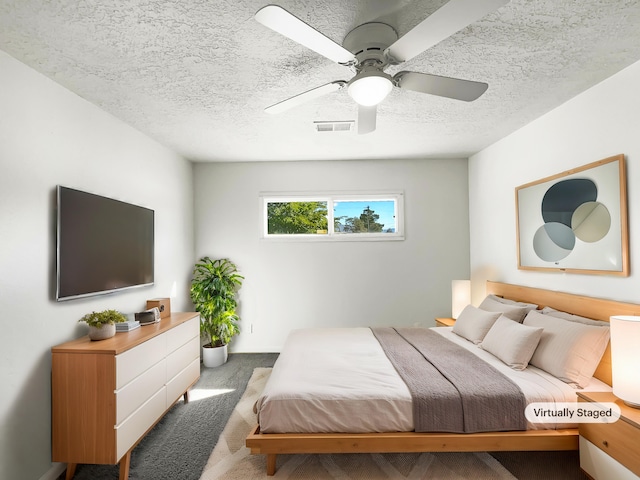 bedroom featuring a textured ceiling, carpet, and ceiling fan