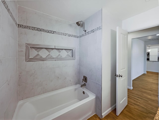 bathroom featuring hardwood / wood-style floors and tiled shower / bath combo