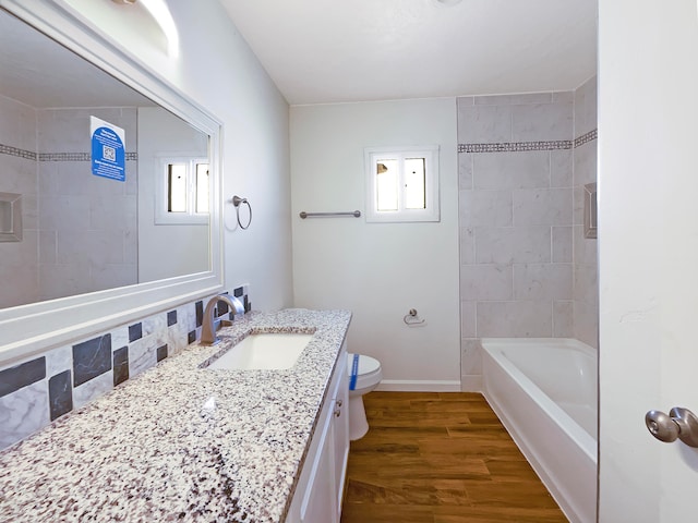 full bathroom with a wealth of natural light, vanity, wood-type flooring, and toilet