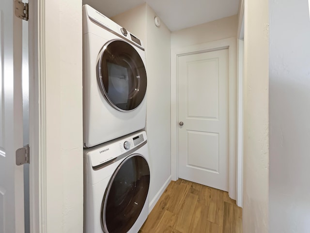 laundry area featuring light hardwood / wood-style floors and stacked washer and dryer