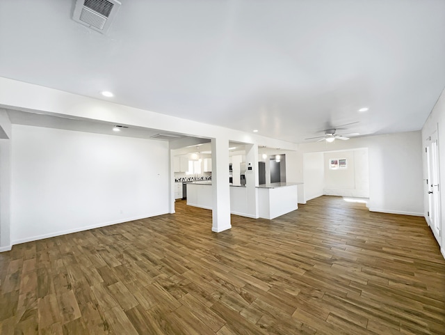 unfurnished living room with dark wood-type flooring and ceiling fan