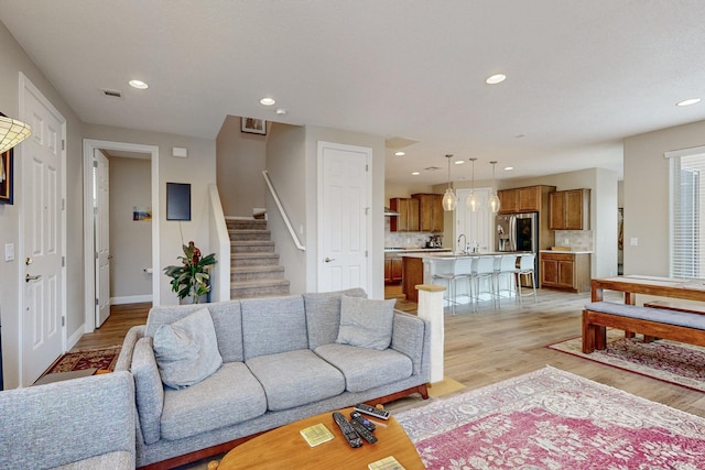 living room with light hardwood / wood-style flooring and sink