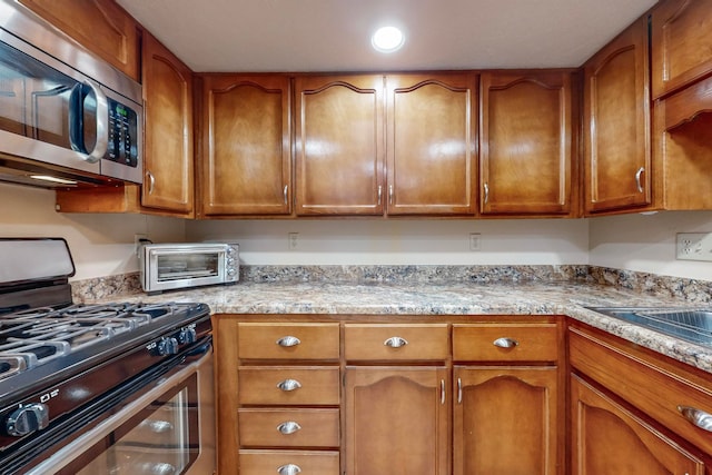 kitchen featuring light stone countertops and appliances with stainless steel finishes