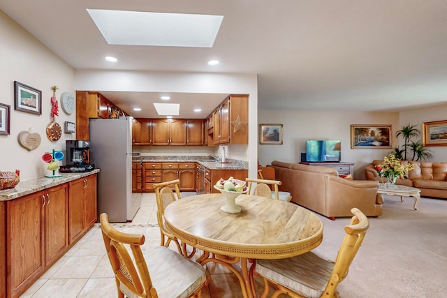 tiled dining area featuring a skylight