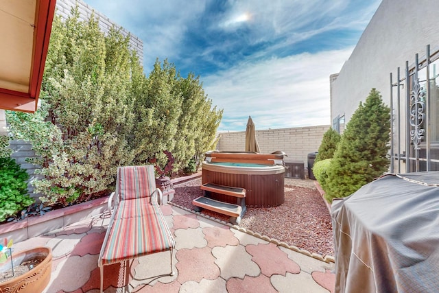 view of patio with area for grilling and a hot tub