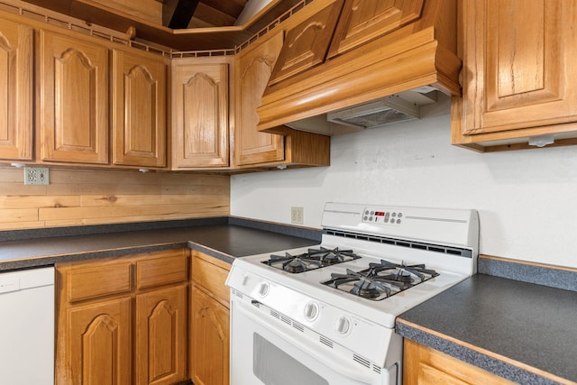 kitchen featuring white appliances and premium range hood